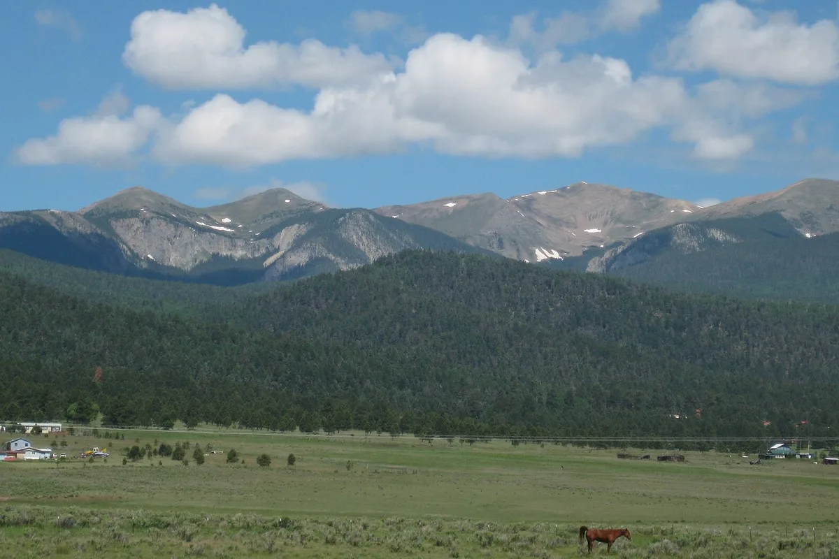 Wheeler Peak and the Sangre de Cristo range above a green valley on the drive into Taos