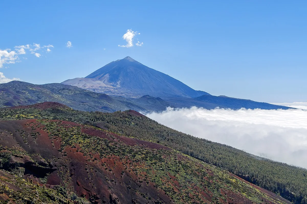 Mount Teide above a sea of cloud, seen across the volcanic slopes of the Cumbre Dorsal