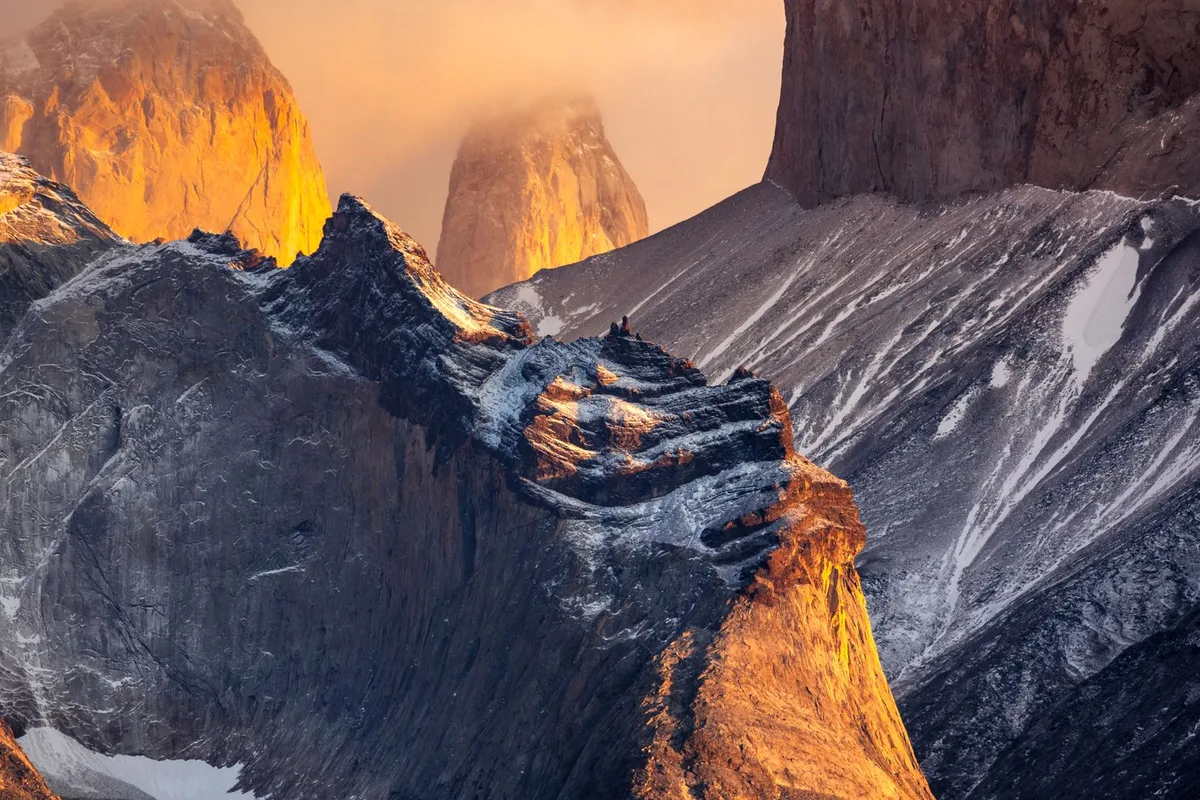 The granite towers of Torres del Paine glowing gold at sunrise