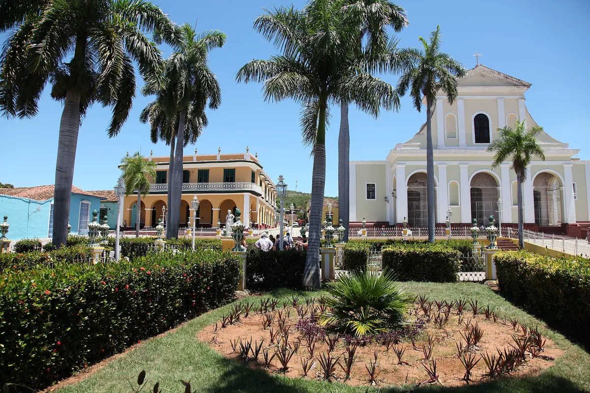 Plaza Mayor in Trinidad, royal palms and the Church of the Holy Trinity over the colonial square