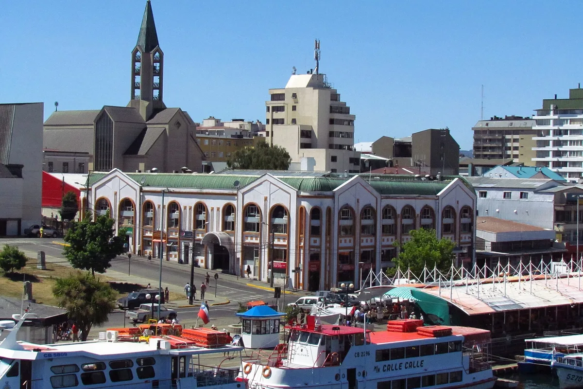 The Mercado Municipal and cathedral across the Calle-Calle river in Valdivia, tour boats at the pier