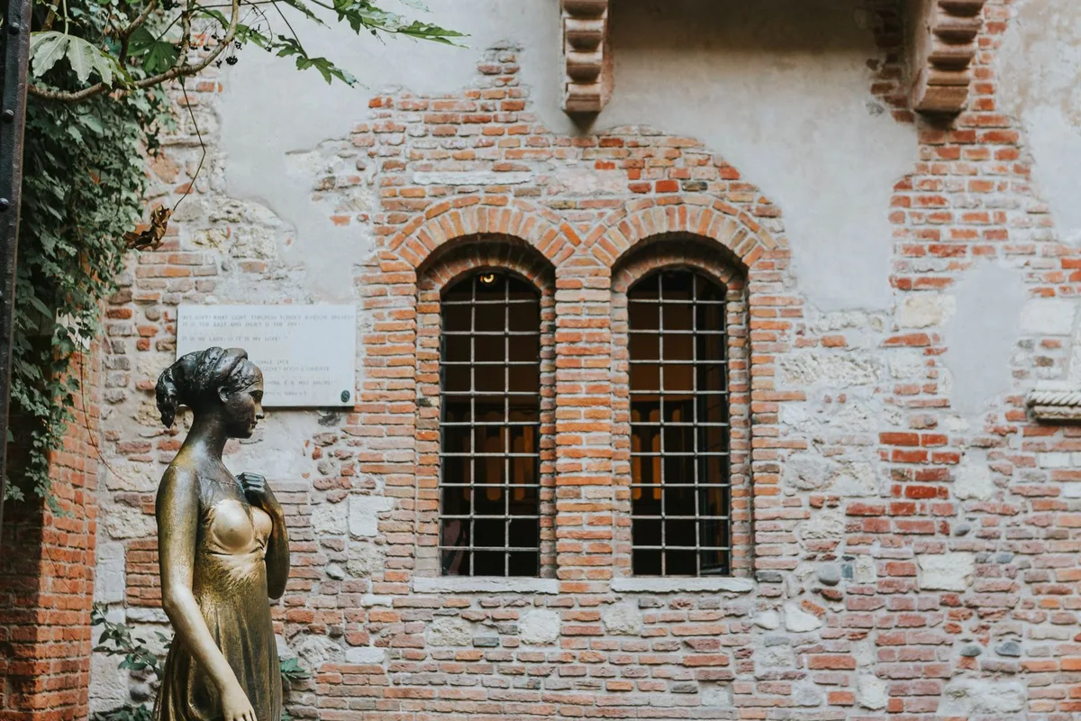 Juliet's balcony and the bronze Juliet statue in the courtyard of the Casa di Giulietta