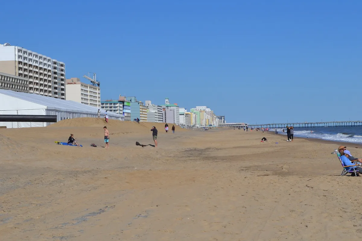 The wide beach at the Virginia Beach oceanfront, hotels along the shore and the fishing pier in the distance
