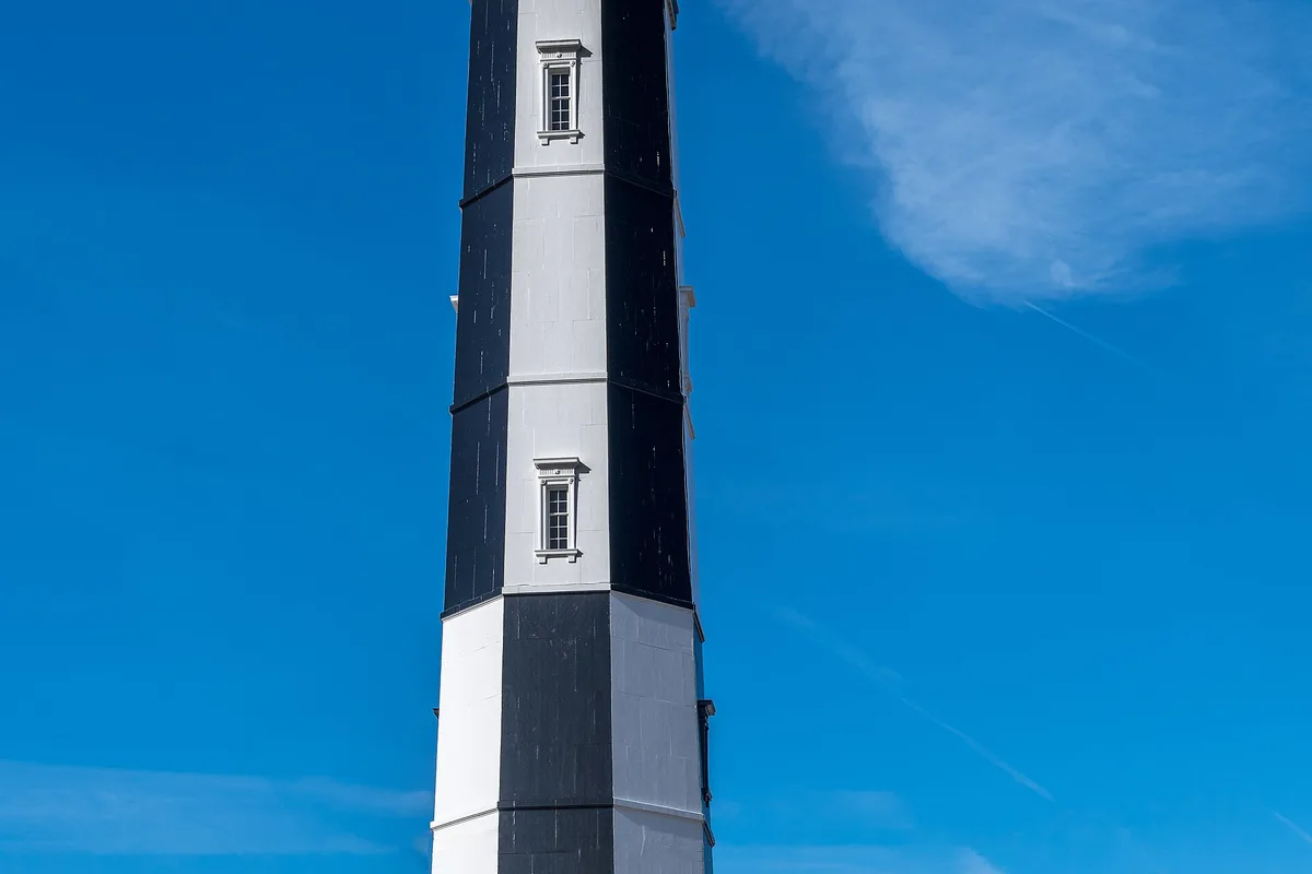 The 1881 Cape Henry Lighthouse at Fort Story, its black and white tower against a blue sky