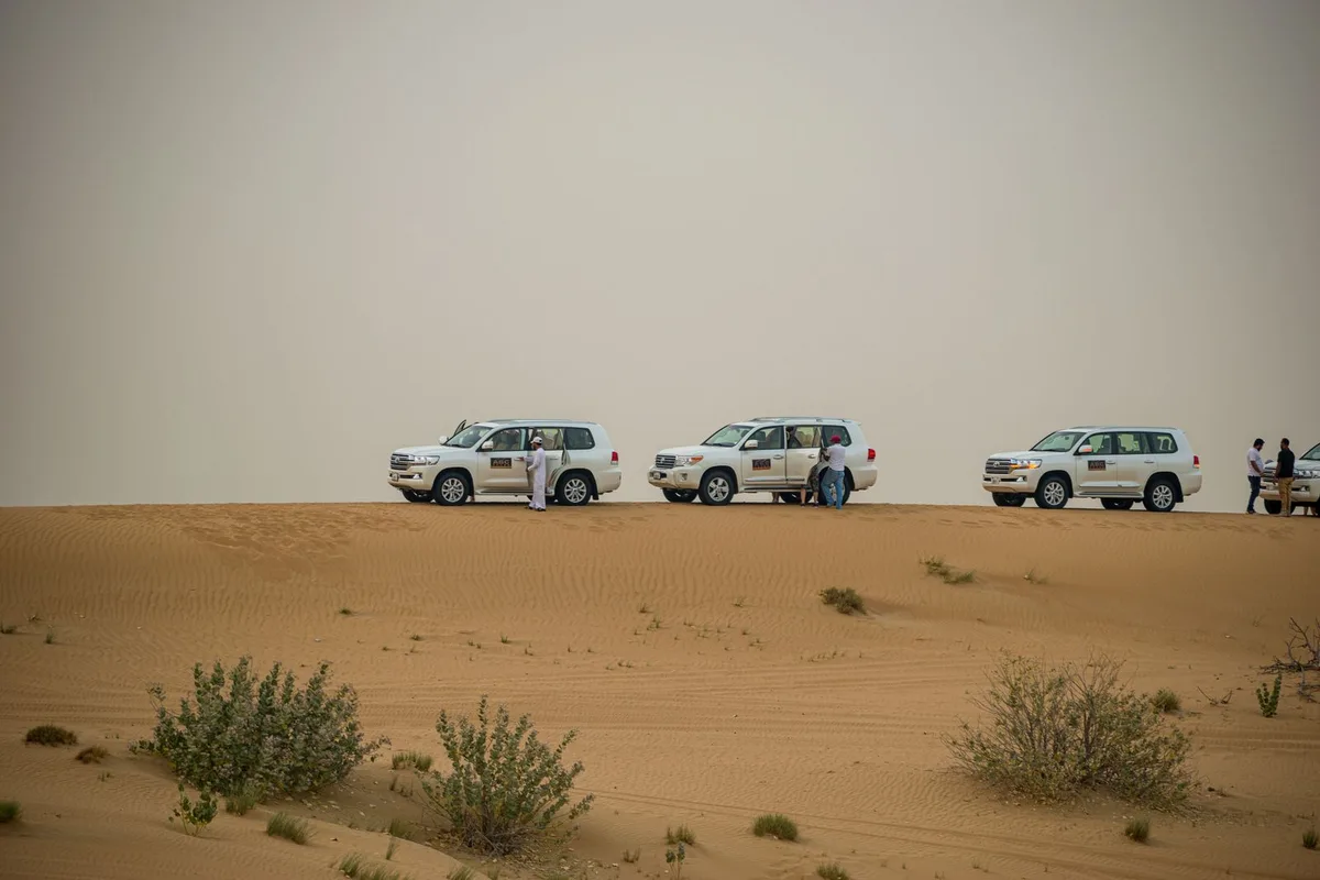 Tour jeeps lined up on the sand at the start of a Wadi Rum desert run