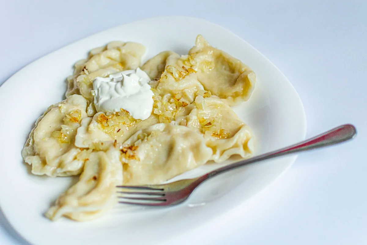 A plate of pierogi with sour cream and fried onion, the essential first meal in Wrocław