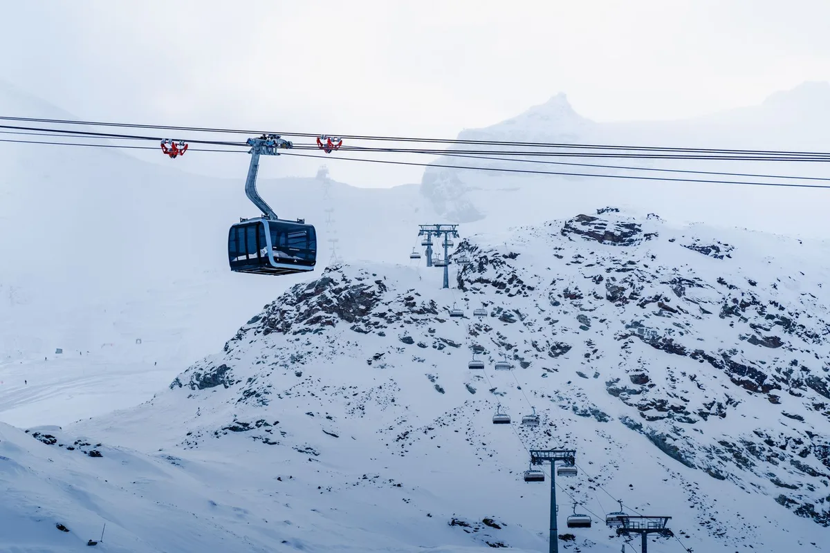 Gondolas climbing over snowy slopes towards the Klein Matterhorn